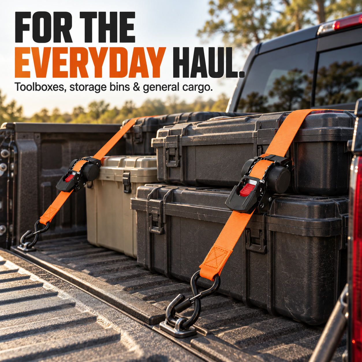 Orange ratchet tie-down straps across storage cases in a pickup bed